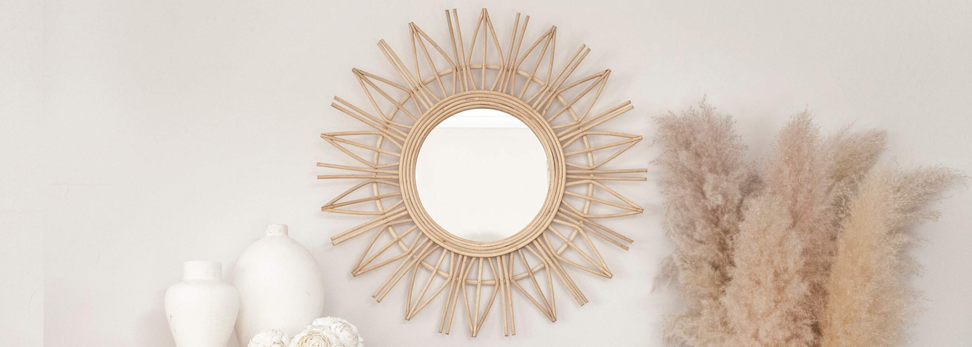 Single Rattan Mirror on a wall styled with white pottery and pampas.